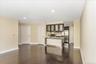 Kitchen with glass insert cabinets, dark brown cabinets, recessed lighting, appliances with stainless steel finishes, and dark wood-style floors