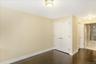 Unfurnished bedroom with dark wood-style flooring, a closet, and ensuite bath