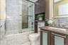 Full bath featuring vanity, backsplash, and bath / shower combo with glass door