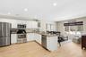 Kitchen with a kitchen breakfast bar, stainless steel appliances, white cabinets, dark stone countertops, and a peninsula