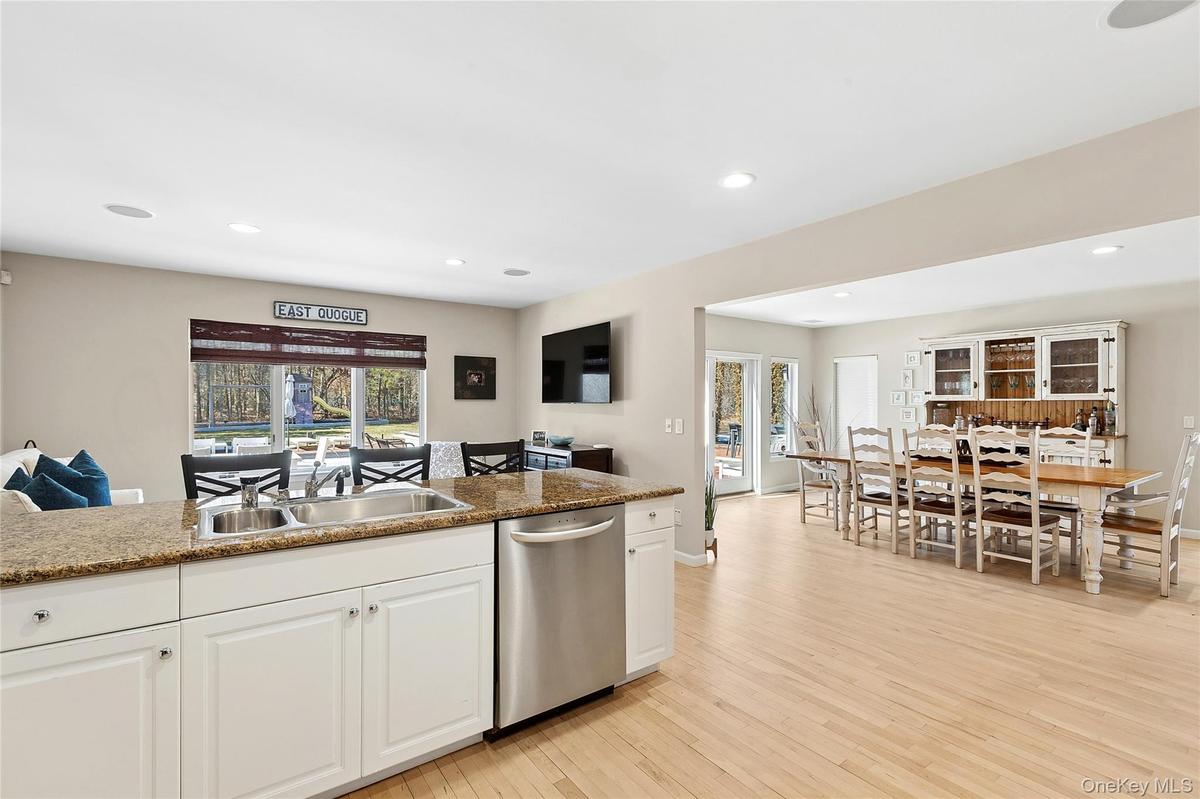 Kitchen featuring dishwasher, white cabinets, light wood-style floors, light stone countertops, and recessed lighting