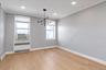 Unfurnished dining area with radiator, light wood-style flooring, hanging lights, cooling unit and recessed lighting