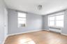 Primary bedroom featuring radiator, light wood-type flooring, master bathroom, walk-in closet, recessed lighting