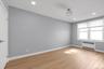 Second bedroom with radiator, light wood-type flooring, recessed lighting