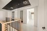 Corridor featuring a raised ceiling and an upstairs landing