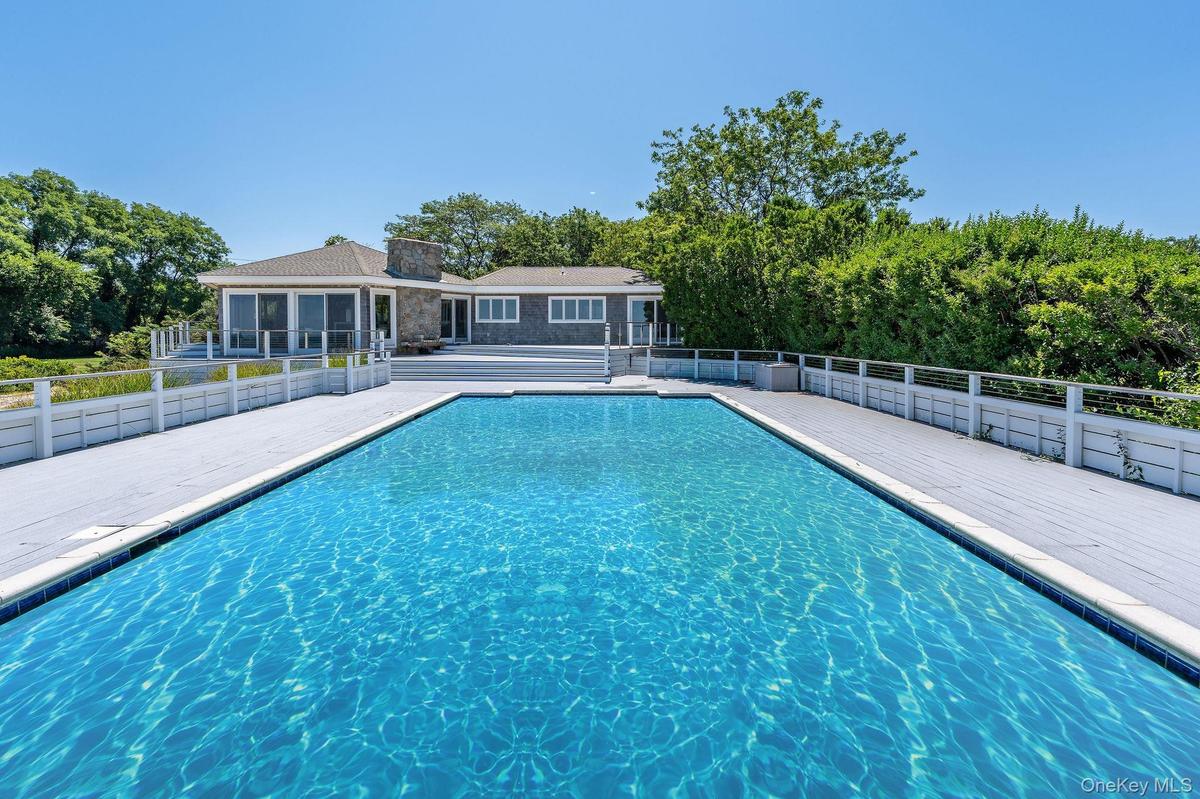 View of swimming pool with a patio and view of scattered trees
