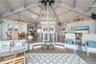 Living room with a notable chandelier, high vaulted ceiling, a healthy amount of sunlight, and wood finished floors