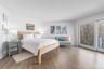 Bedroom featuring baseboards, access to exterior, and wood finished floors