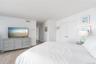 Bedroom featuring wood finished floors, baseboards, and visible vents