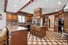 Kitchen with black appliances, a sink, arched walkways, tasteful backsplash, and a peninsula