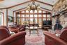 Living area featuring high vaulted ceiling, beamed ceiling, and a stone fireplace