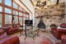 Living area with high vaulted ceiling, beamed ceiling, and a fireplace