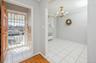 Doorway to outside with a chandelier, ornamental molding, radiator heating unit, finished floors, and arched walkways