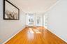 Living room with arched walkways, crown molding, light wood-type flooring, radiator, and recessed lighting