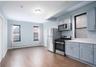 Kitchen with stainless steel appliances, gray cabinetry, and healthy amount of natural light