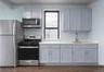 Kitchen with stainless steel appliances, light stone countertops, gray cabinetry, and dark wood-style flooring