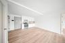 Kitchen featuring white cabinetry, stainless steel range with electric cooktop, light countertops, light wood-type flooring, and open floor plan