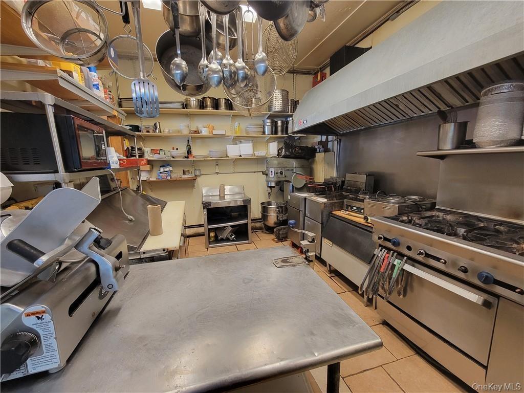 Kitchen with light tile patterned flooring, extractor fan, and open shelves