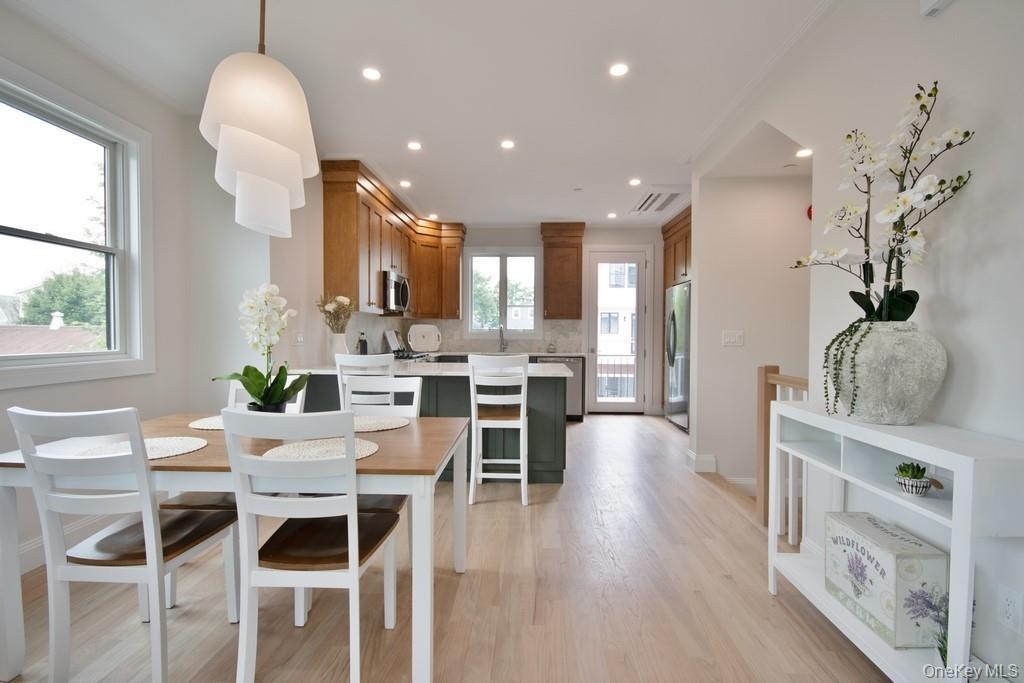 Dining area with light wood-style flooring and recessed lighting