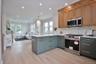 Kitchen with stainless steel appliances, decorative backsplash, light wood-style floors, light stone countertops, and recessed lighting