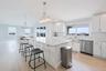 Kitchen with dishwasher, a kitchen bar, healthy amount of natural light, vaulted ceiling, and recessed lighting