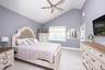 Bedroom with light wood-style flooring, high vaulted ceiling, and a ceiling fan