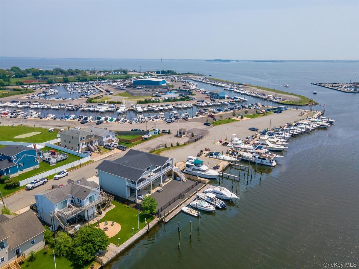 Drone / aerial view of numerous boat docks and a nearby body of water