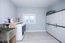 Laundry room with independent washer and dryer, light wood-style flooring, and cabinet space