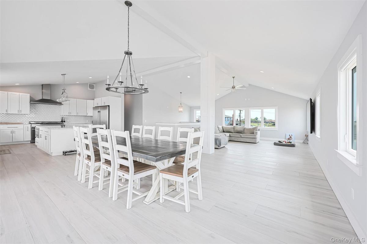 Dining area featuring ceiling fan, high vaulted ceiling, light wood-style floors, and recessed lighting