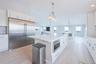 Kitchen with built in appliances, healthy amount of natural light, a center island, light wood-style flooring, and recessed lighting