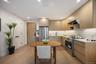 Kitchen with modern cabinets, appliances with stainless steel finishes, light wood-style floors, recessed lighting, and range hood
