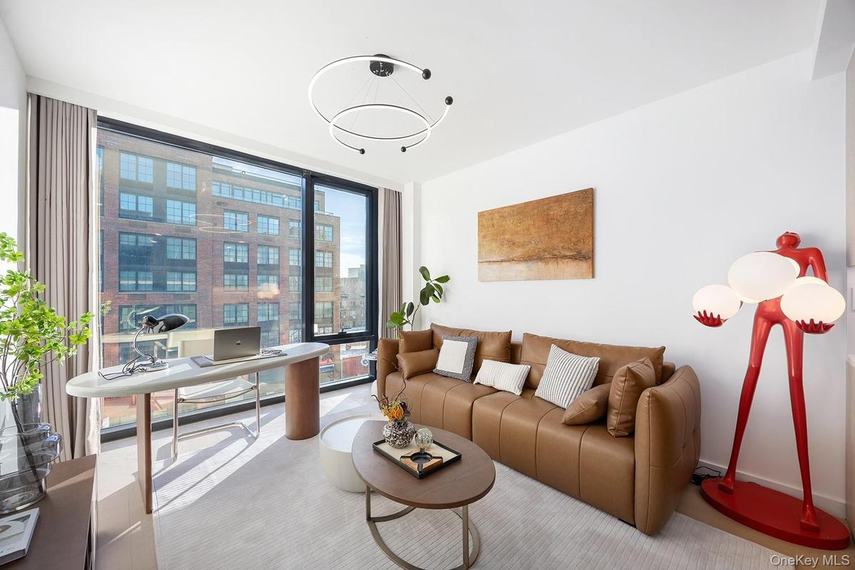 Living area with an office area and a wall of windows