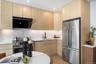 Kitchen featuring light brown cabinetry, modern cabinets, stainless steel appliances, light wood-type flooring, and recessed lighting