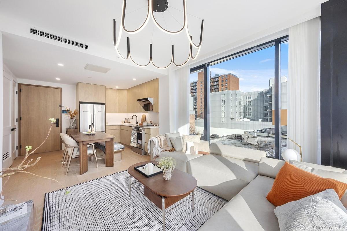 Living area with a chandelier, floor to ceiling windows, a view of city, and recessed lighting