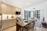 Kitchen with light brown cabinetry, expansive windows, modern cabinets, appliances with stainless steel finishes, and range hood