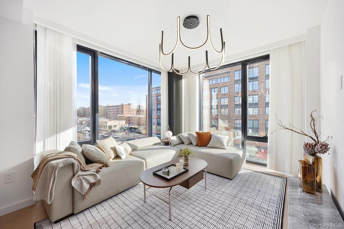 Living room featuring expansive windows, a chandelier, and a city view