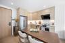Kitchen with light brown cabinetry, modern cabinets, stainless steel appliances, light wood-type flooring, and ventilation hood