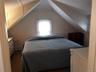Carpeted bedroom with a decorative wall and a baseboard heating unit
