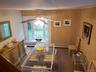 Dining area featuring ceiling fan, wooden walls, and baseboard heating