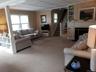 Carpeted living room with stairway, built in shelves, and a fireplace