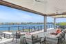 Wooden deck with an outdoor hangout area, a ceiling fan, and a water view