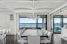 Dining space with a chandelier, dark wood-style flooring, a water view, and plenty of natural light