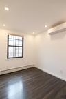 Bedroom featuring baseboard heating, dark wood-style flooring, and an AC wall unit