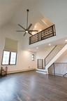 Unfurnished living room featuring light wood finished floors, loft-like 2nd floor overlook and high ceilings