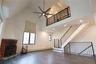 Unfurnished living room featuring light wood finished floors, loft-like 2nd floor overlook and high ceilings