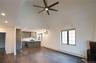 Unfurnished living room featuring baseboard heating, dark wood finished floors, and healthy amount of natural light