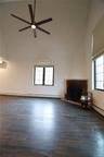 Unfurnished living room featuring baseboard heating, dark wood finished floors, and healthy amount of natural light