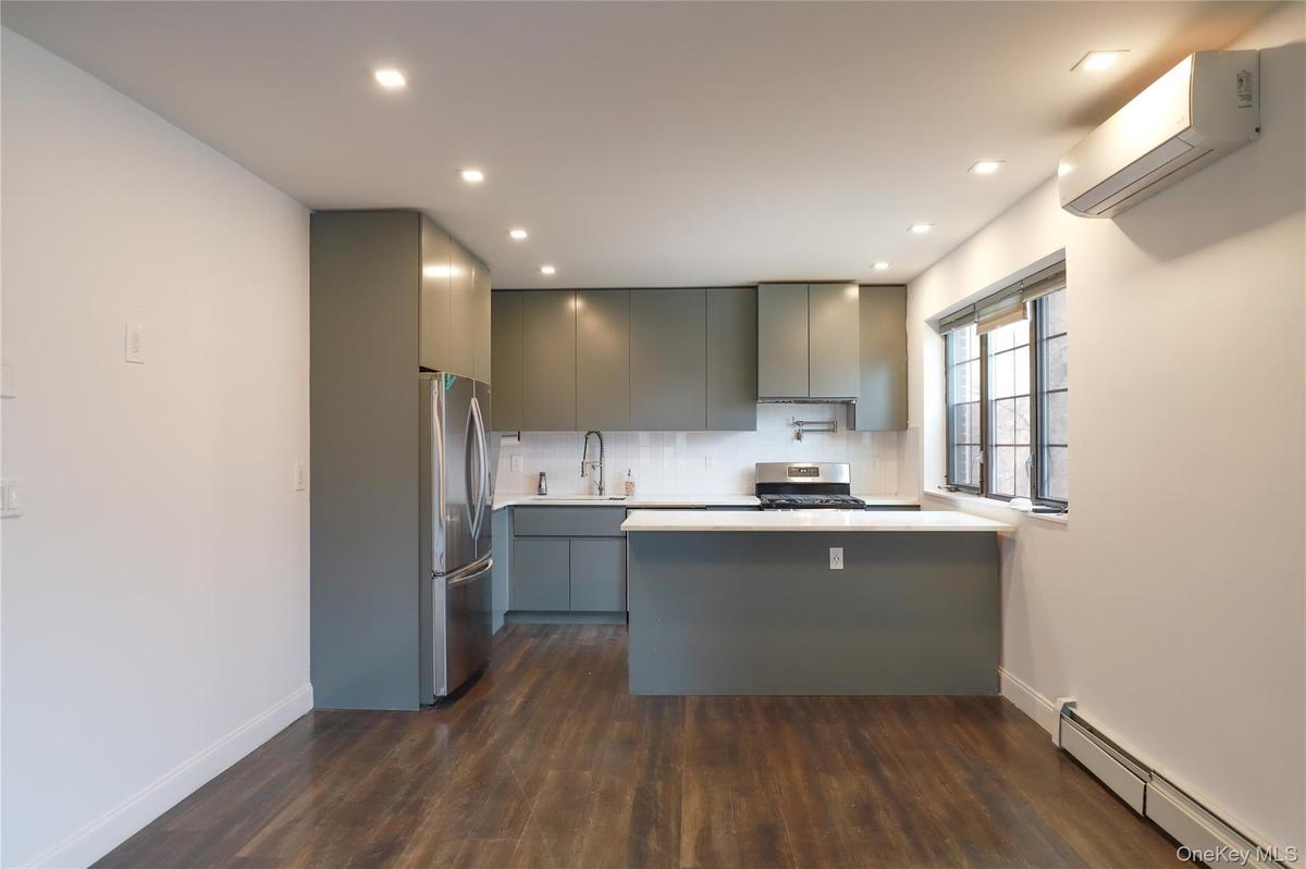 Kitchen featuring a peninsula countertop, stainless steel appliances, a wall mounted AC