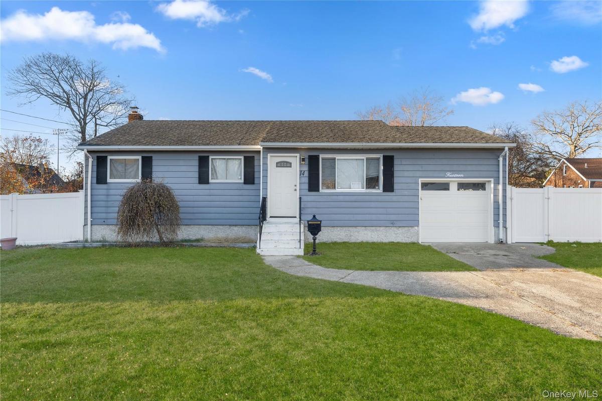 Ranch-style house featuring a gate, concrete driveway, and a garage