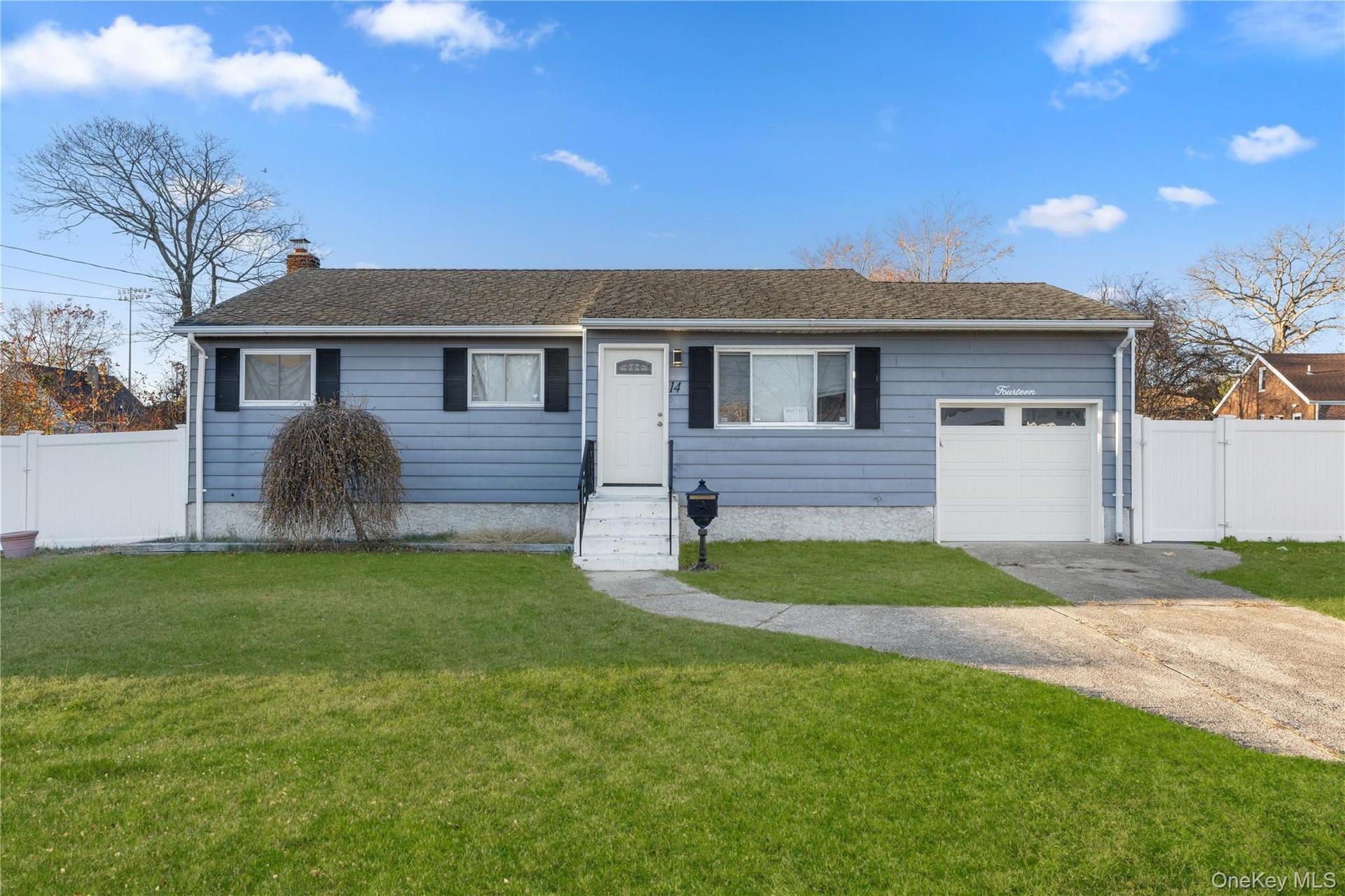 Ranch-style house featuring a gate, concrete driveway, and a garage